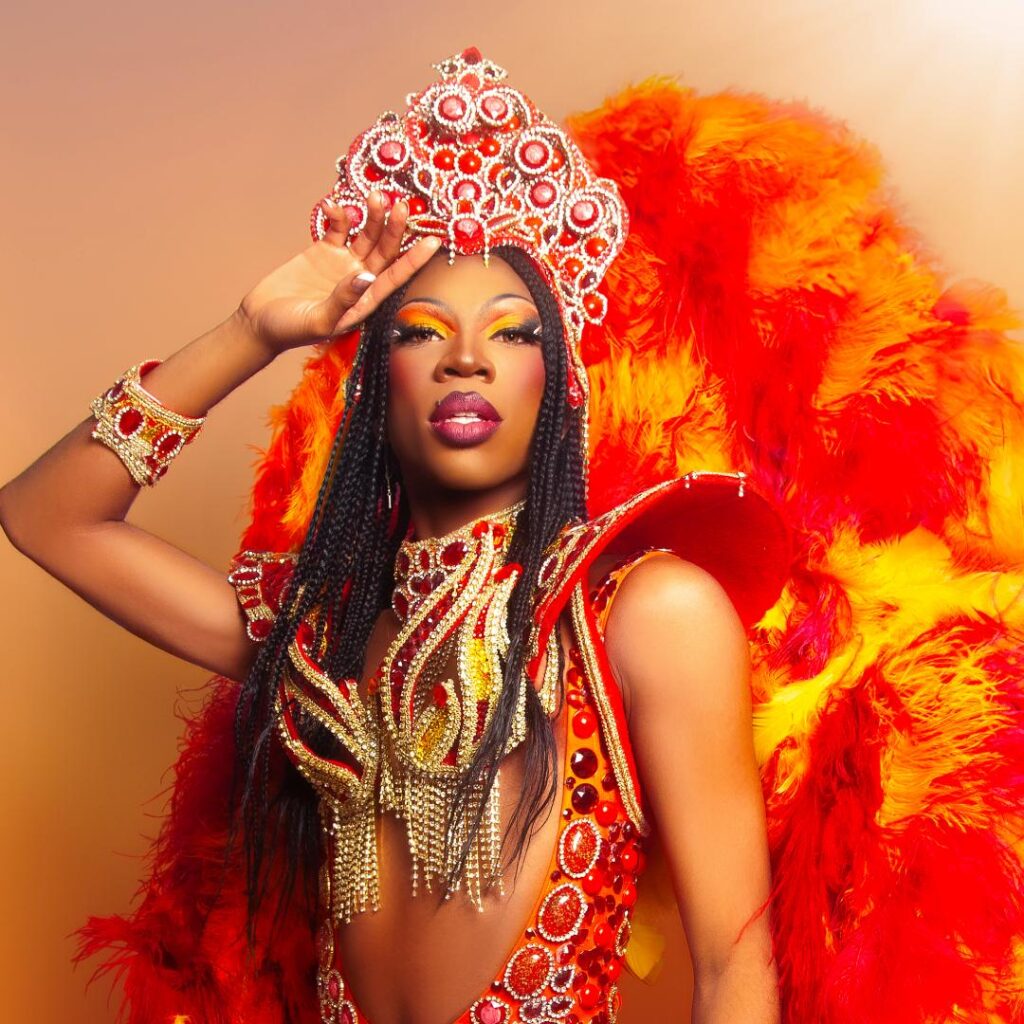 A person wearing a bright orange costume and crown