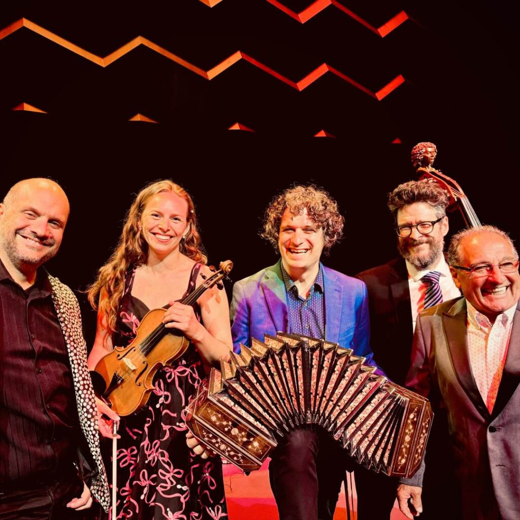 A group of musicians holding musical instruments on stage