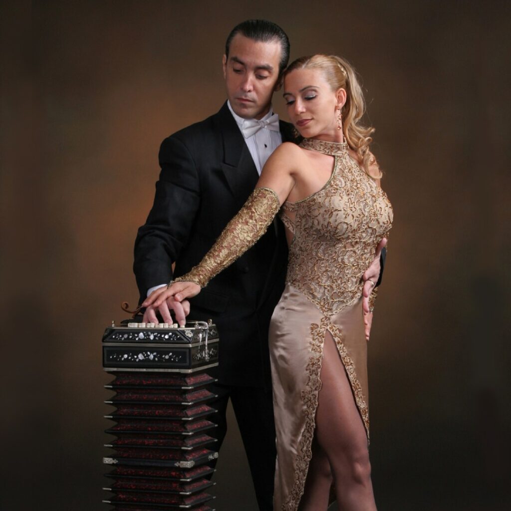 A dancing couple wearing a dress and suit posing