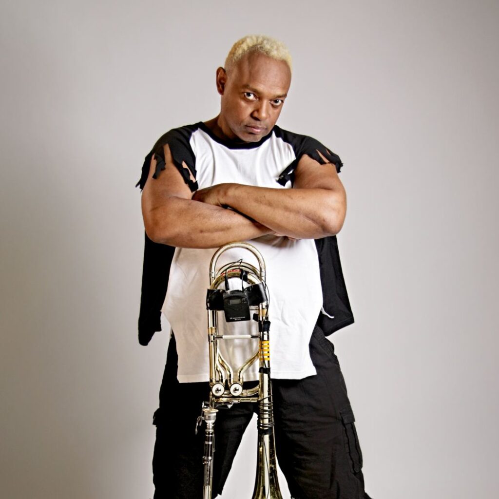 A man with arms crossed posing with his musical instrument
