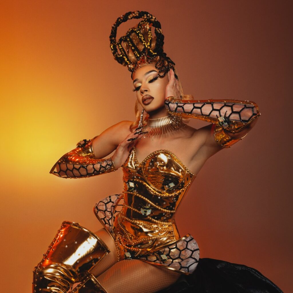 A person wearing a gold costume sitting