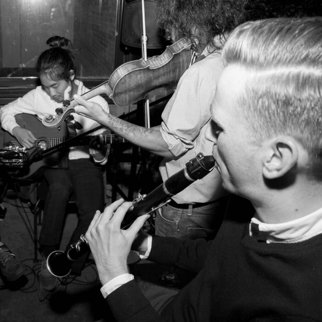 A black and white image of a band playing musical instruments