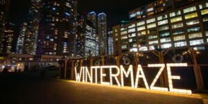 An outdoor maze at night with a lighted sign Winter Maze