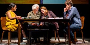 A group of four people talking at a table