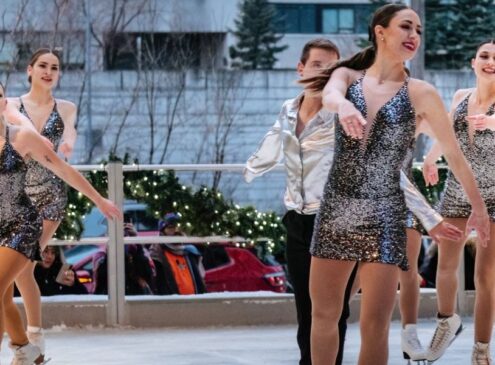 A group of figure skaters in costume skating