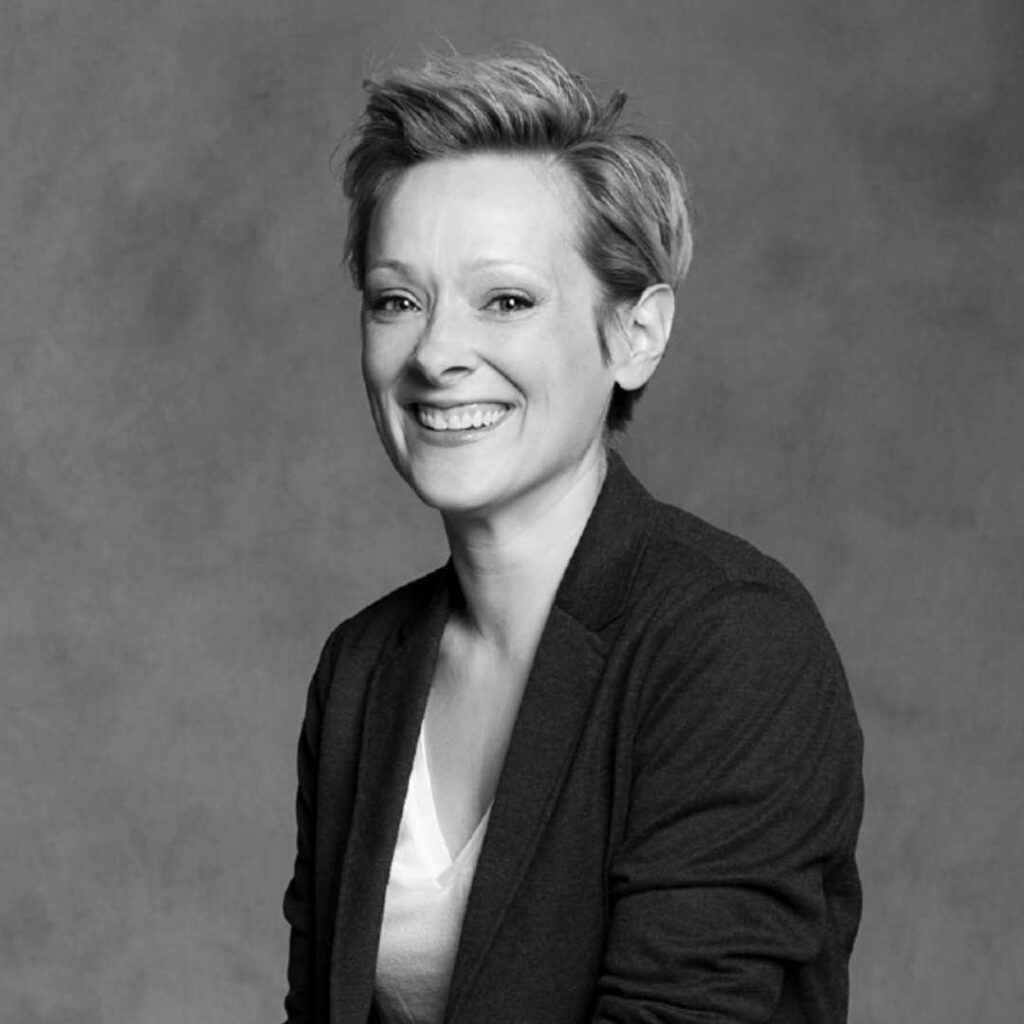 A black and white headshot of a woman smiling