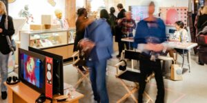 A blurred image of people interacting with an arts exhibition