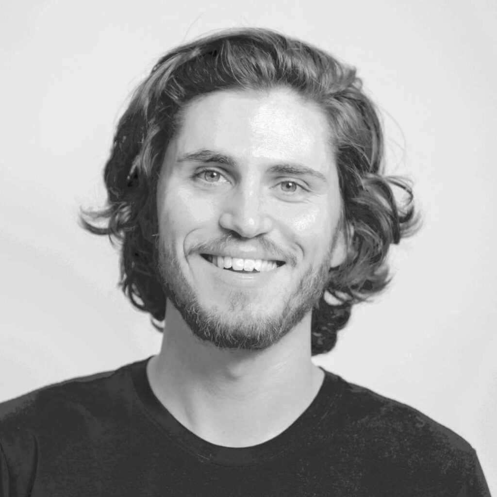 A black and white headshot of a man smiling