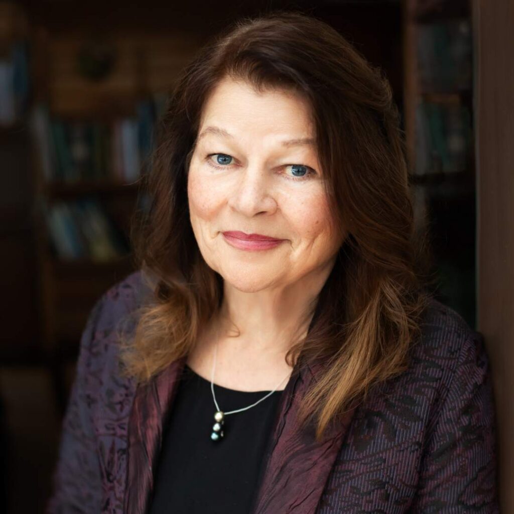 A woman posing for the camera wearing a dark sweater