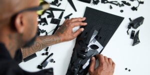 A man working on a black coloured artwork