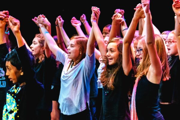 A group of girls doing a theatre performance holding hands