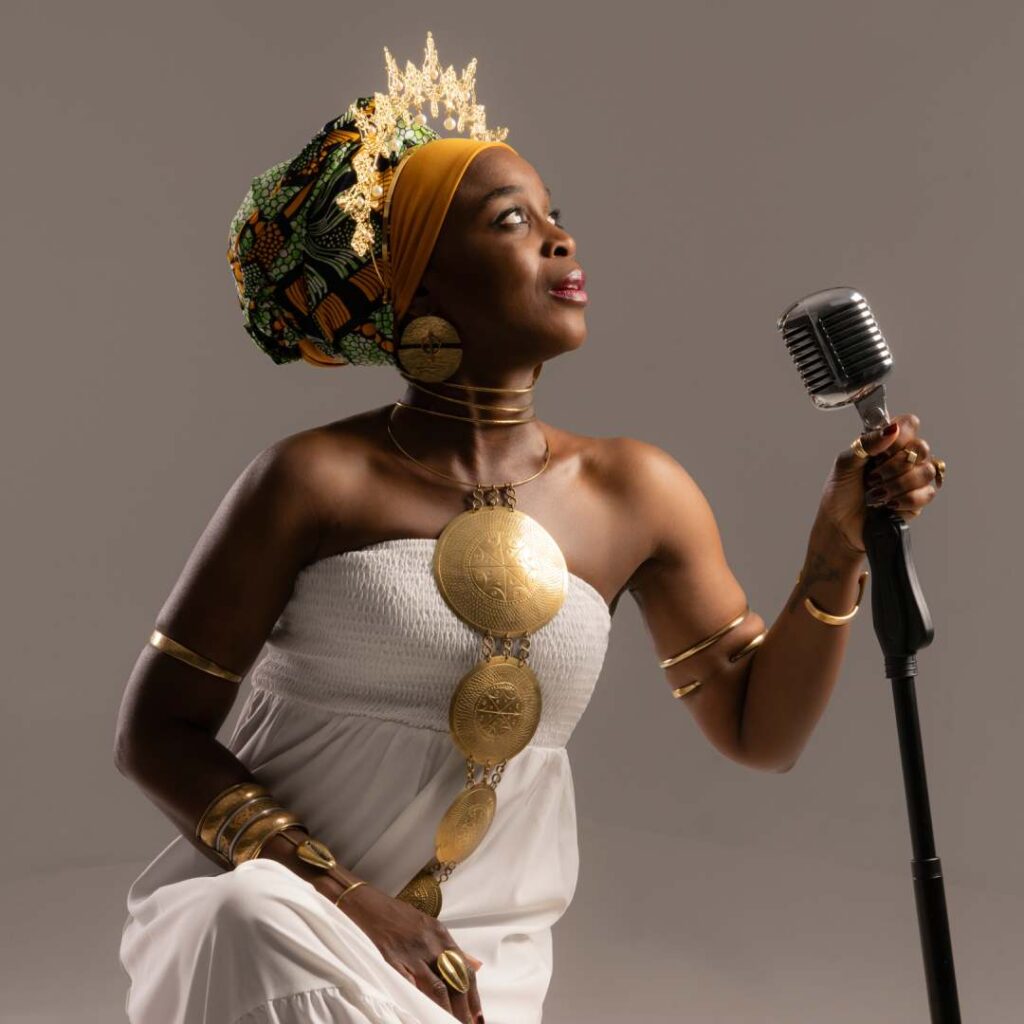 A woman holding a mic wearing a white dress looking into the distance