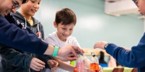 A group of boys working on a science experiment with water bottles.