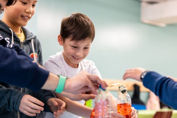 A group of boys working on a science experiment with water bottles.