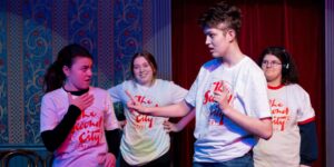 A group of kids doing theatre improv on stage