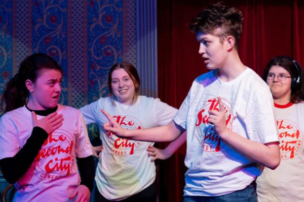 A group of kids doing theatre improv on stage