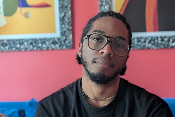 A man sitting on a blue couch posing for the camera