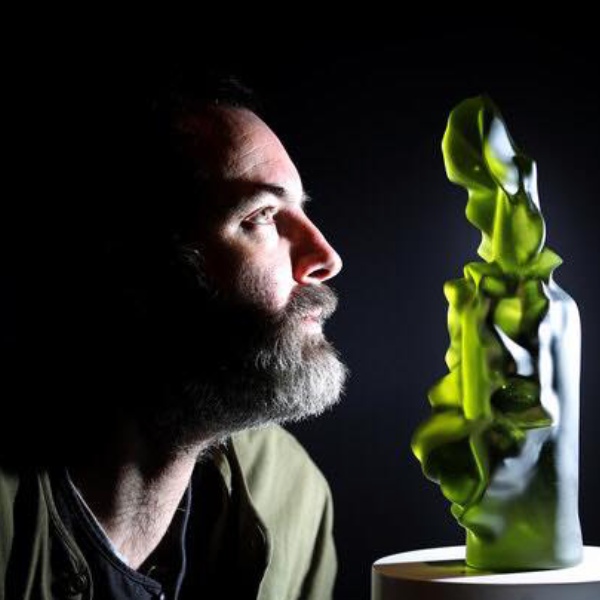 A man looking at a green object in the dark