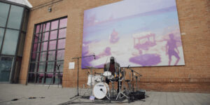 Larnell Lewis performing in front of a brick wall