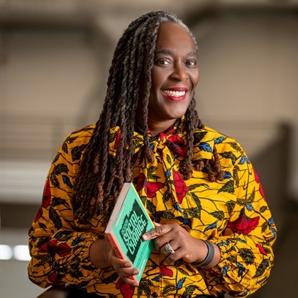 A woman wearing a bright yellow dress smiling for the camera