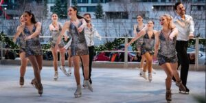 A group of figure skaters on ice in costume