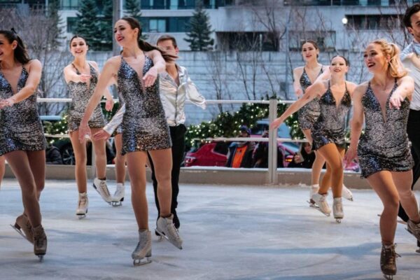 A group of figure skaters on ice in costume