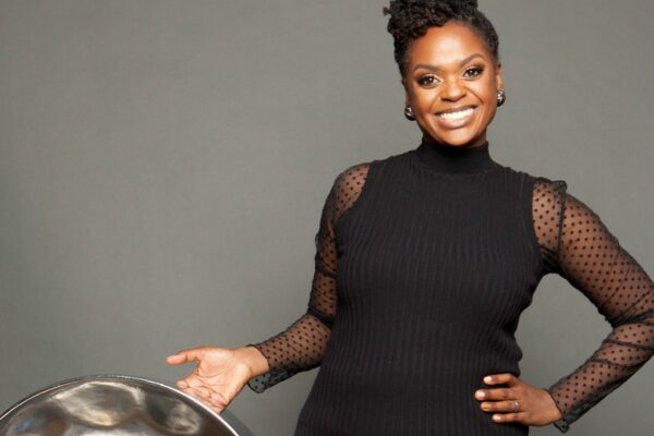 A woman wearing a black dress holding a percussion instrument