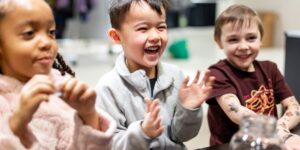 A group of kids smiling in a classroom