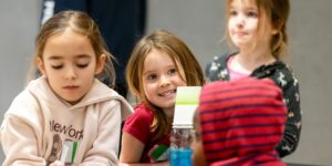 A group of kids smiling in a classroom