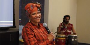 A woman wearing bright clothing holding a microphone