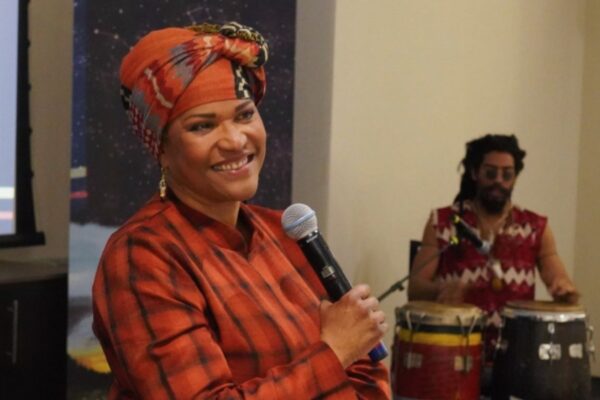 A woman wearing bright clothing holding a microphone