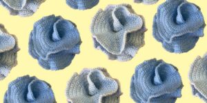 Multiple blue crocheted pieces against a light yellow background