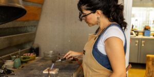 An artist working on a metal piece in the studio