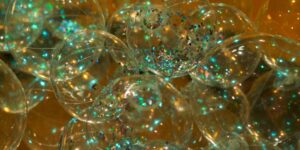 A close-up image of transparent spheres with colourful sparkles.