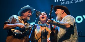 Three musicians performing with their musical instruments on stage