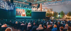 An audience watching an outdoor movie at night