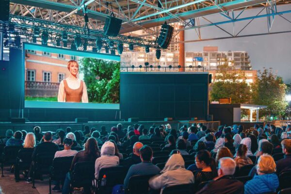 An audience watching an outdoor movie at night