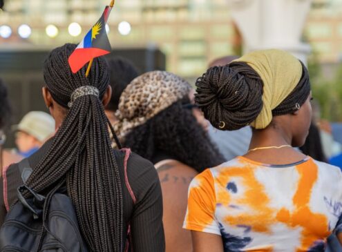 Two women standing in a crowd by an outdoor stage