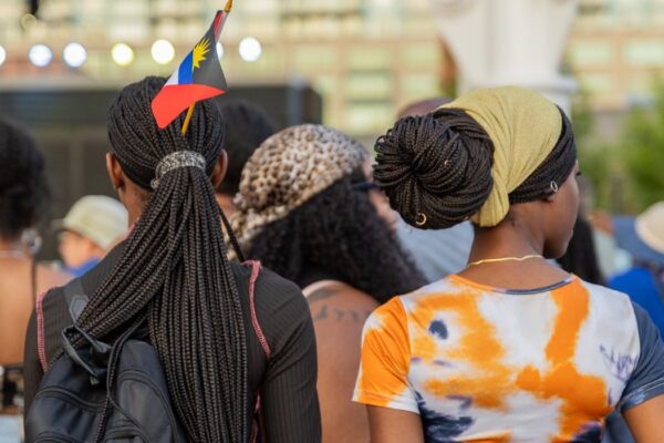 Two women standing in a crowd by an outdoor stage