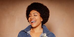 A woman smiling with her eyes closed.