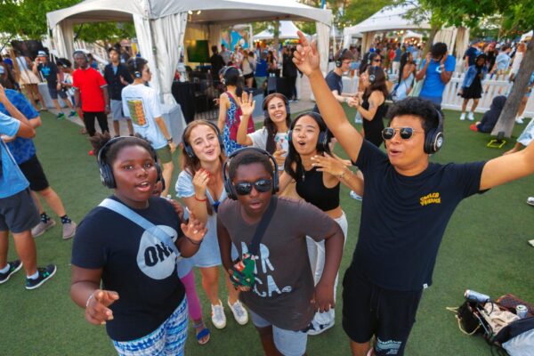 A group of kids doing Silent Disco wearing headphones outdoors