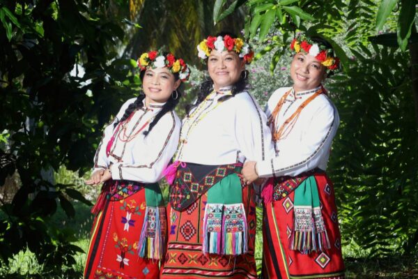 A group of three women in red attire posing for the camera