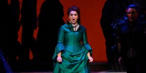 An opera singer in a blue costume on stage performing