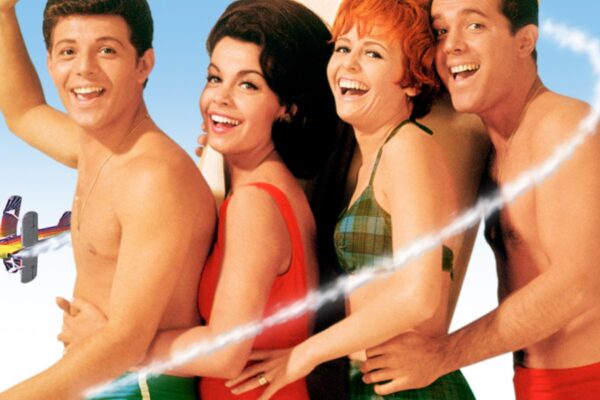 Four people in swimsuits posing next to each other smiling for the camera
