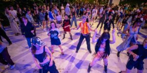 A crowd of people participating in an outdoor evening dance class