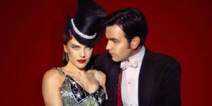 A Moulin Rouge film still of a couple against a red background