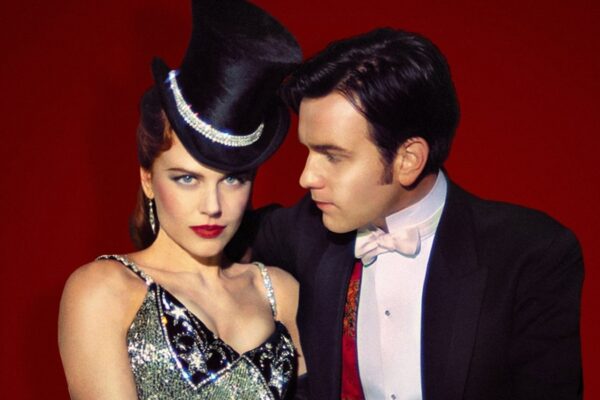 A Moulin Rouge film still of a couple against a red background