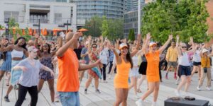 A woman teaching an outdoor dance class.