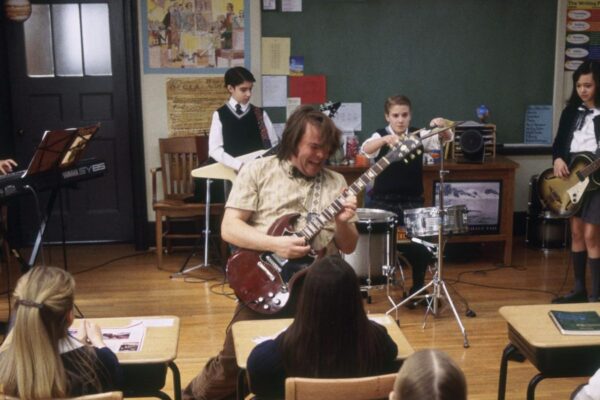 A School of Rock film still of a teacher playing guitar in a classroom