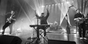 A black and white shot of a band performing on stage